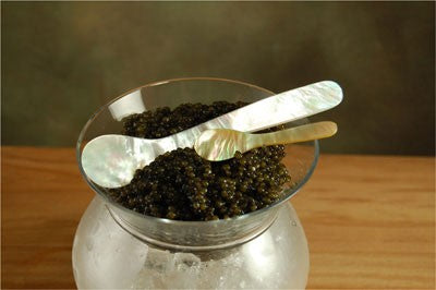mother of pearl caviar spoon in open jar