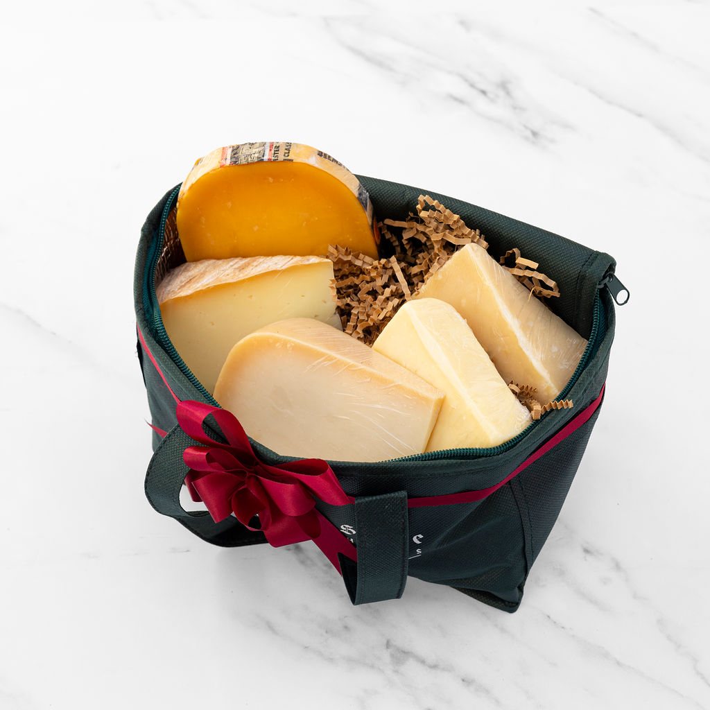 Better with Cheese: five cheeses in a green Cheese Store bag tied with a red bow