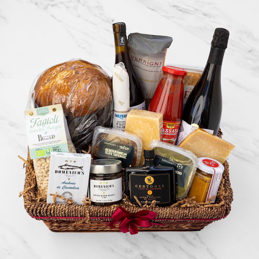 Il Domenico gift basket with panettone, sparkling wine, Parmigiano and Domenico's pantry, tied with a red bow